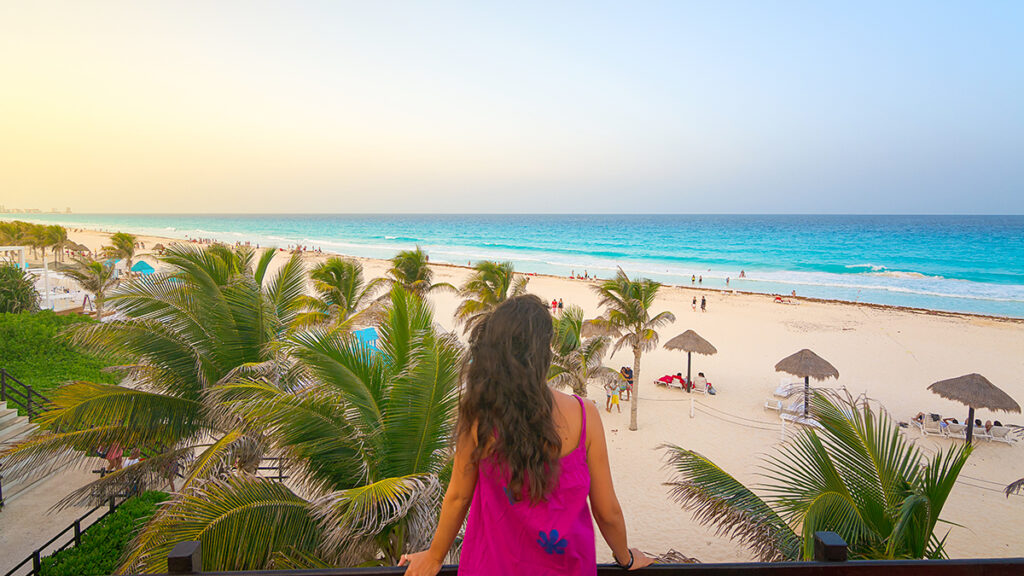 Young woman watching the beautiful Cancun beach at sunset, Mexic