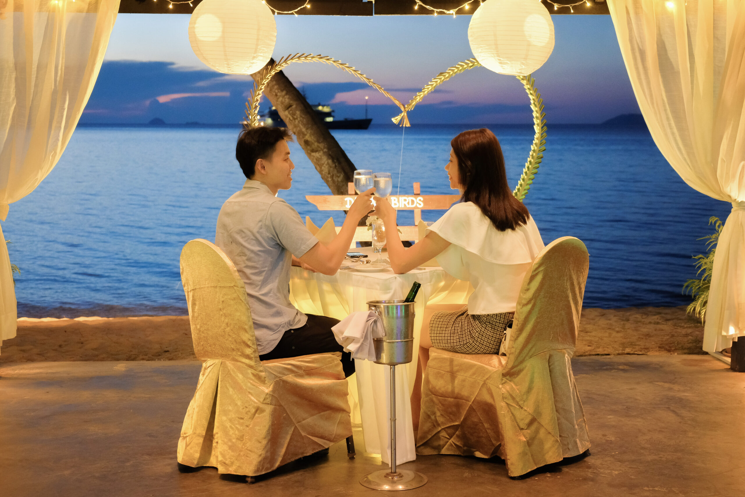 Young couple enjoying a romantic dinner by candlelight, outdoor in maldives. Enjoy maldives vacation with Halo flights USA.